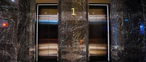 Un ascensor de mármol con un cartel que indica el número '1', señalando el primer piso.