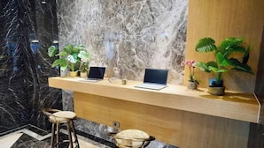 A reception desk with two laptops, two potted plants, and two stools. - Dragon River Hotel (Nantou)