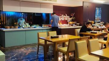 A restaurant with a counter, tables, and chairs.