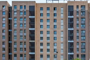 A multi-story residential building with a uniform facade, numerous windows, and a central air conditioning unit. - Bonilyi Hotel (Ningbo Beilun Yintai City ) (Ningbo)