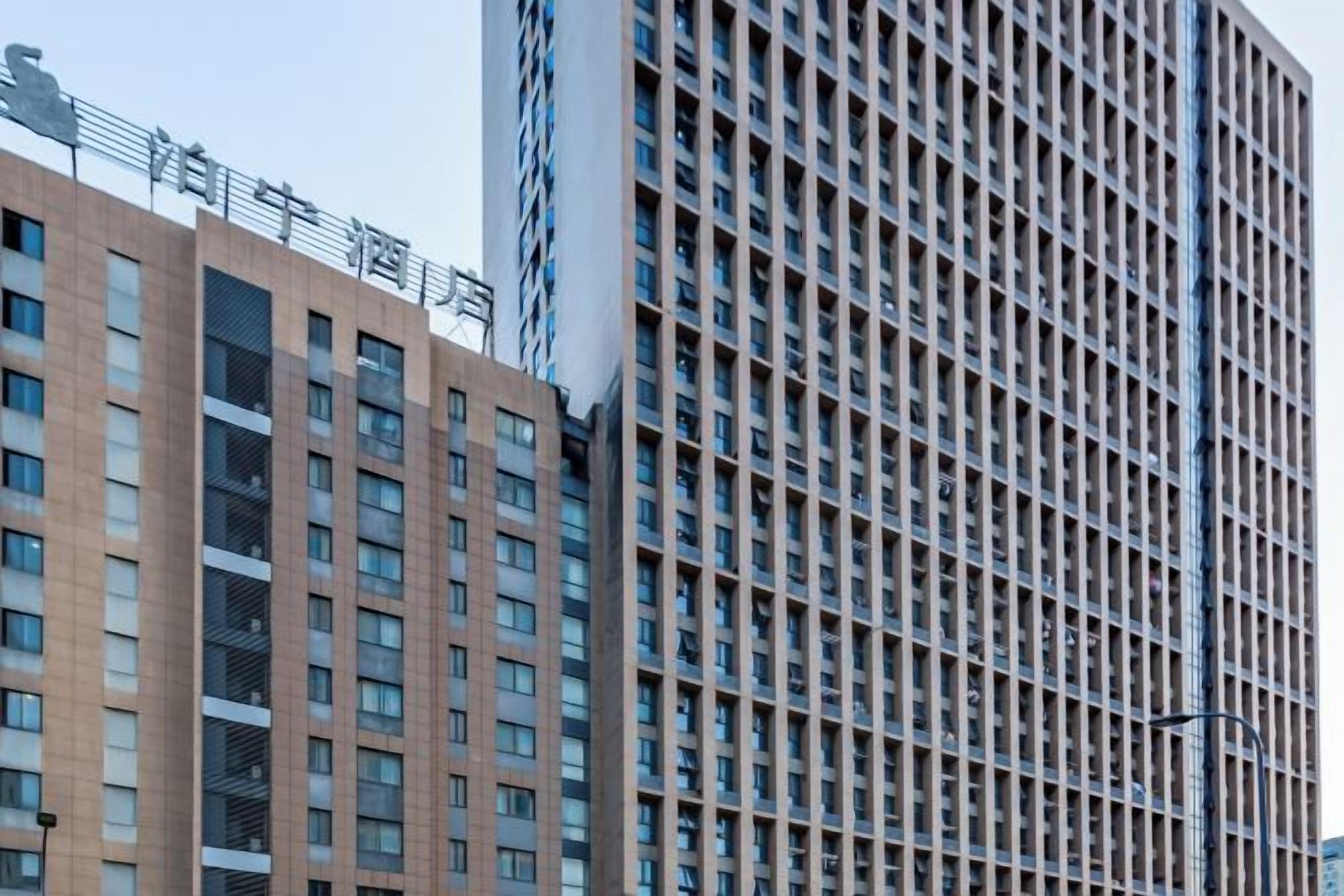 A high-rise building with a grid-like facade and multiple balconies.