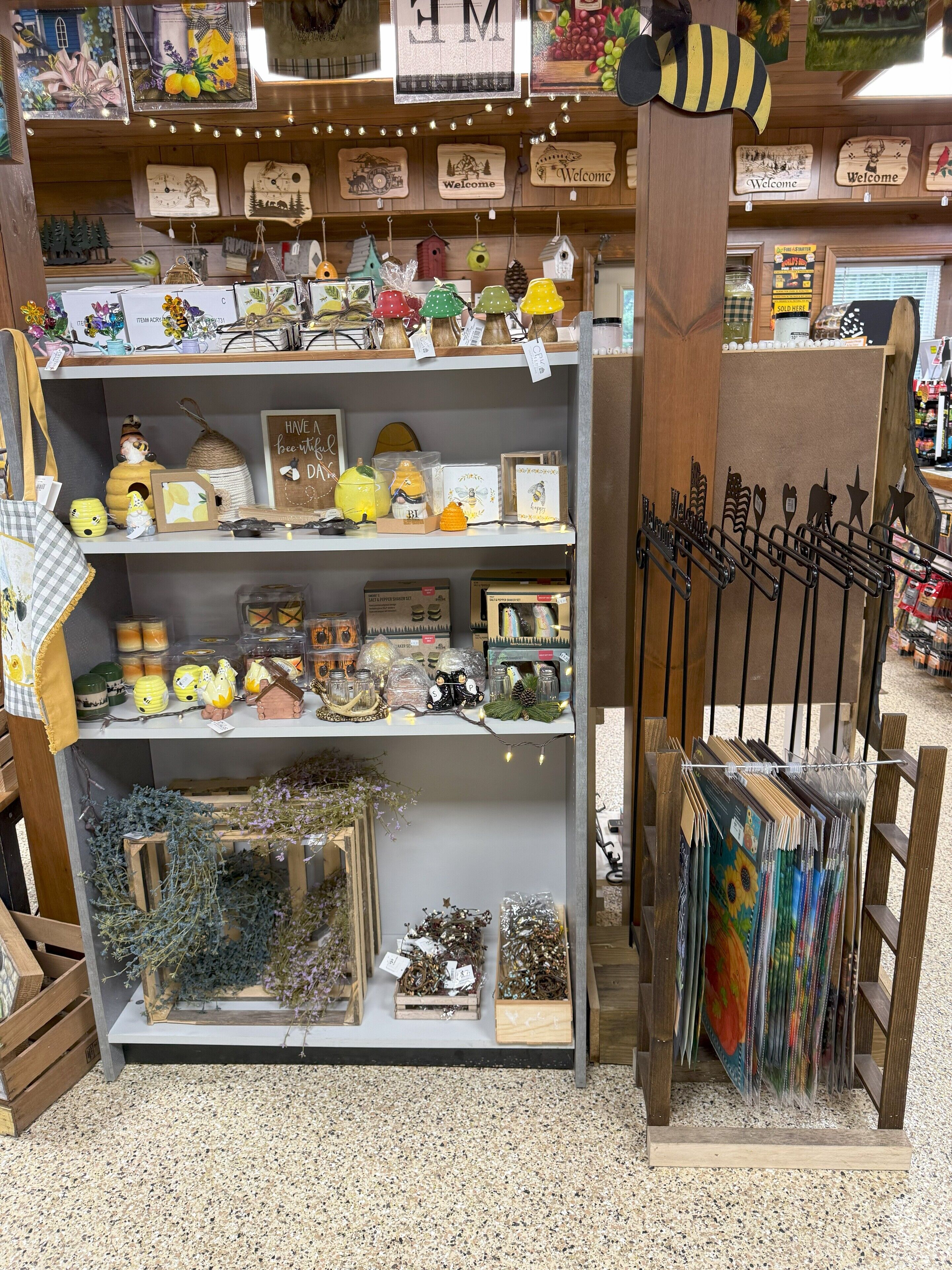 A store with shelves of decorative items, including birdhouses, lanterns, and framed pictures.