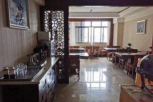 Un hall de hotel con mostrador de recepción, zona de estar y amplias ventanas.