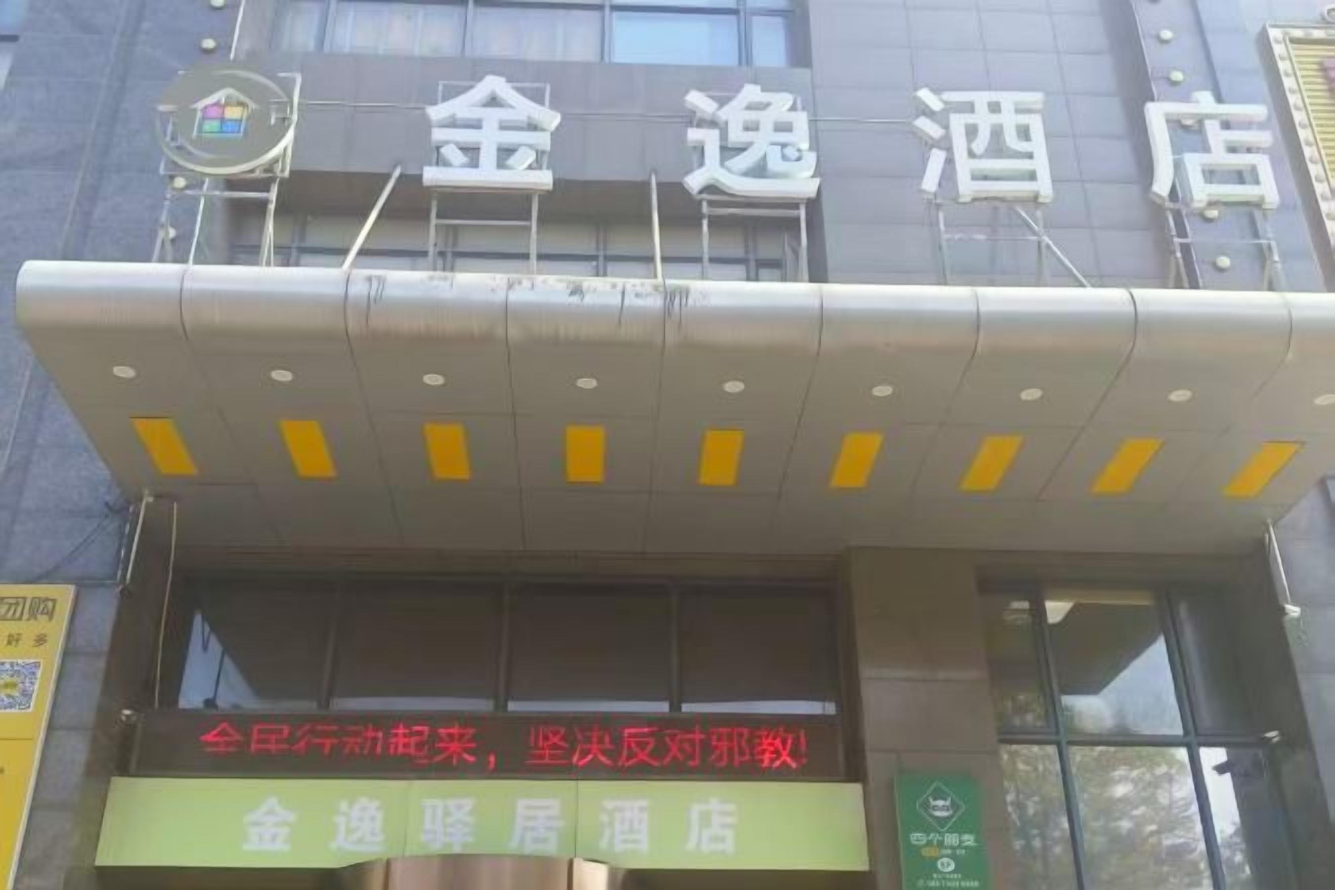 A hotel entrance with a signboard displaying the hotel's name.