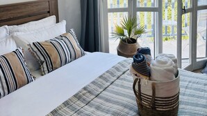 Un dormitorio con una cama grande, vistas a un balcón y un cuadro en la pared.