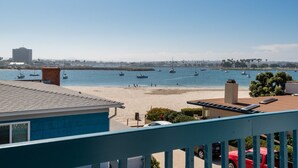 A beach with boats, a building, and a clear sky.