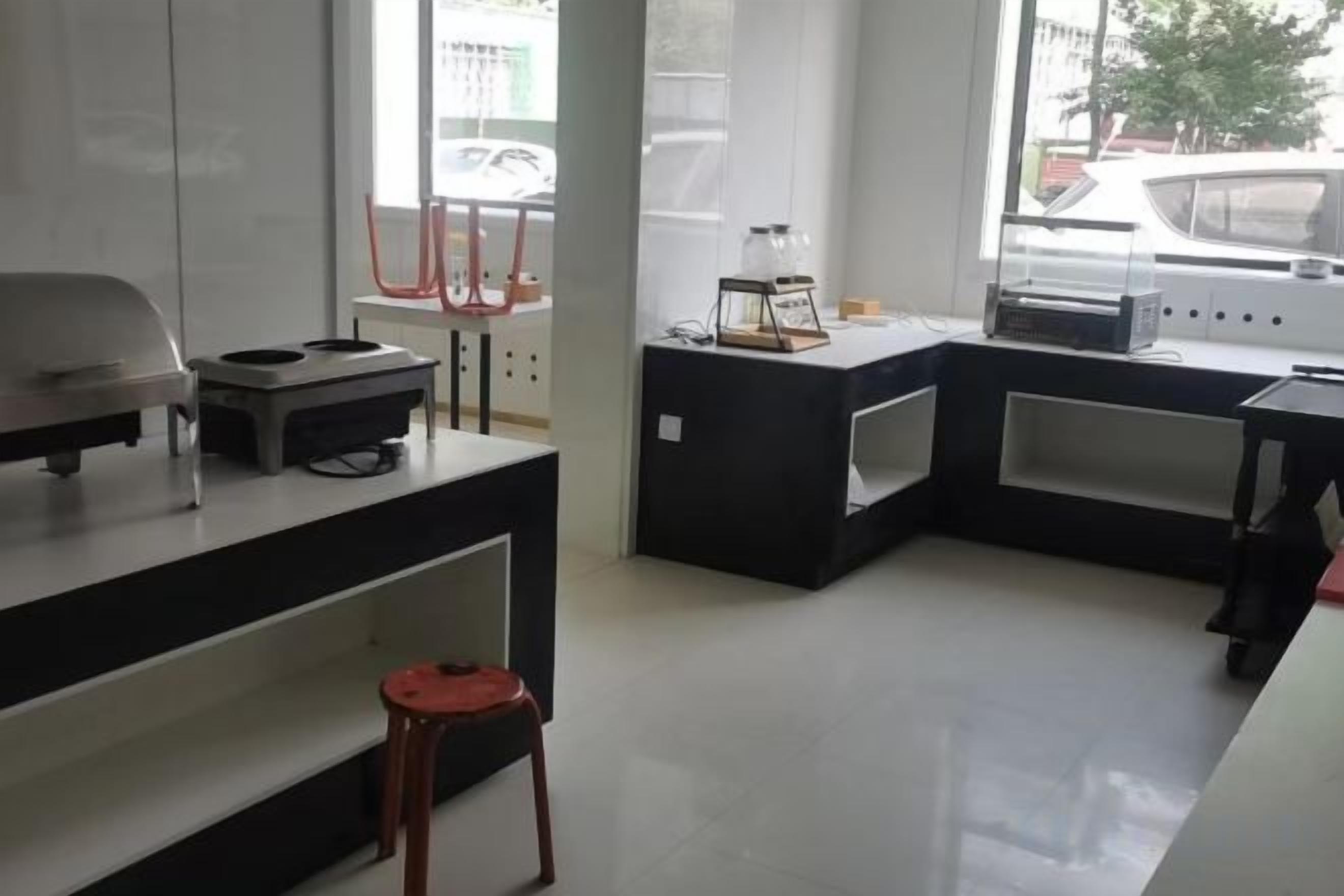 Una cocina moderna con encimera, un lavabo y un ventanal con vistas a la calle.