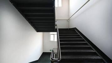 A staircase with a handrail, a landing area, and a window at the top.