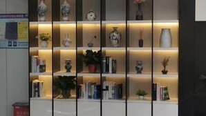 Una estantería con diversos objetos decorativos y libros.