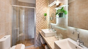 Une salle de bain moderne avec une douche à parois de verre, un lavabo blanc et un grand miroir.