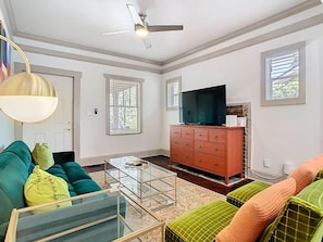 A living room with a sofa, a coffee table, a television, and a fireplace.
