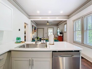 A modern kitchen with a central island, stainless steel appliances, and a view to the dining area.