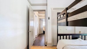 Una habitación de hotel con literas, un armario y suelo alfombrado.
