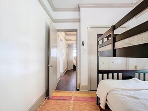 Una camera d'albergo con un letto a castello, un armadio e pavimento in moquette.