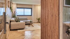 A modern living room with a sofa, a coffee table, and a wooden partition.