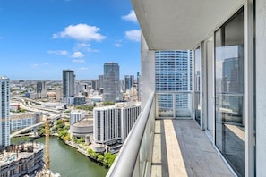 Un edificio alto con vista a un paisaje urbano, incluyendo un río y otros edificios.