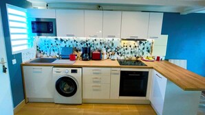 A compact kitchen with a washing machine, microwave, and dishwasher. - Beautiful apartment with sea view (Marigot)