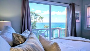 A bedroom with a large bed, a view of the ocean, and a balcony with a railing. - Ocean Front 4 Bedroom with Private Pool (St. Thomas)