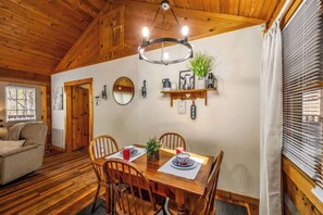 A cozy dining area with a wooden table, chairs, and a chandelier. - Quiet-Hot Tub-Fireplace-Honeymoon-Hiking-Relax (Sevierville)