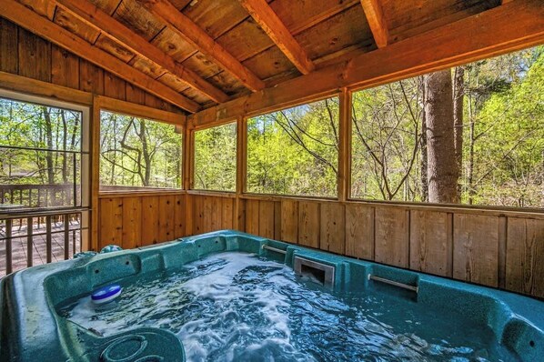 A wooden cabin with a hot tub and large windows overlooking a forest. - Quiet-Hot Tub-Fireplace-Honeymoon-Hiking-Relax (Sevierville)