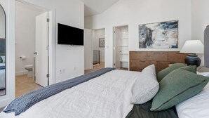 A bedroom with a bed, a TV, a painting, and a nightstand. - Summer Getaway: Hot tub & Cold Plunge, Gear-dryer (Salt Lake City)