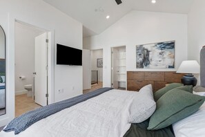 A bedroom with a bed, a TV, a painting, and a nightstand. - Summer Getaway: Hot tub & Cold Plunge, Gear-dryer (Salt Lake City)