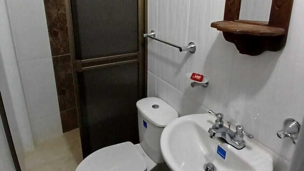Un baño con inodoro, lavabo y espejo.