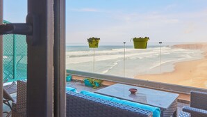 A balcony with wicker furniture and a view of the beach. - Surf & Fun Beachfront Stay in Mirleft With Balcony (Mirleft)