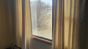 A room with a window, curtains, and a radiator. - Amaris Inn (Redfield)