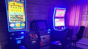 A gaming area with slot machines and chairs. - Amaris Inn (Redfield)