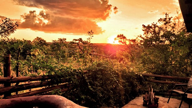 A person relaxing in a hot tub with a sunset view. - Buena Vista Bio Chalet (High Paradise of Goiás)