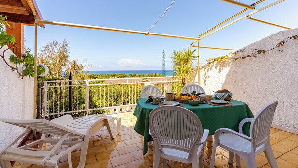 A covered outdoor dining area with a table set for four, overlooking a scenic view. - Villa see view - 5min walk to the beach (Scaro-reggio-Scornavacca-vardano)