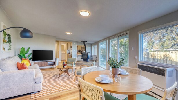 A modern living room with a sofa, TV, dining table, and chairs. - New Remodel! +5 bedroom+Game Room+Sauna+Theater (Denver)
