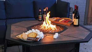 A fire pit table with snacks, drinks, and a fire burning. - New Remodel! +5 bedroom+Game Room+Sauna+Theater (Denver)