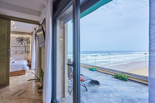 Enjoy stunning ocean views from the balcony, featuring a comfortable bed and a potted plant.
