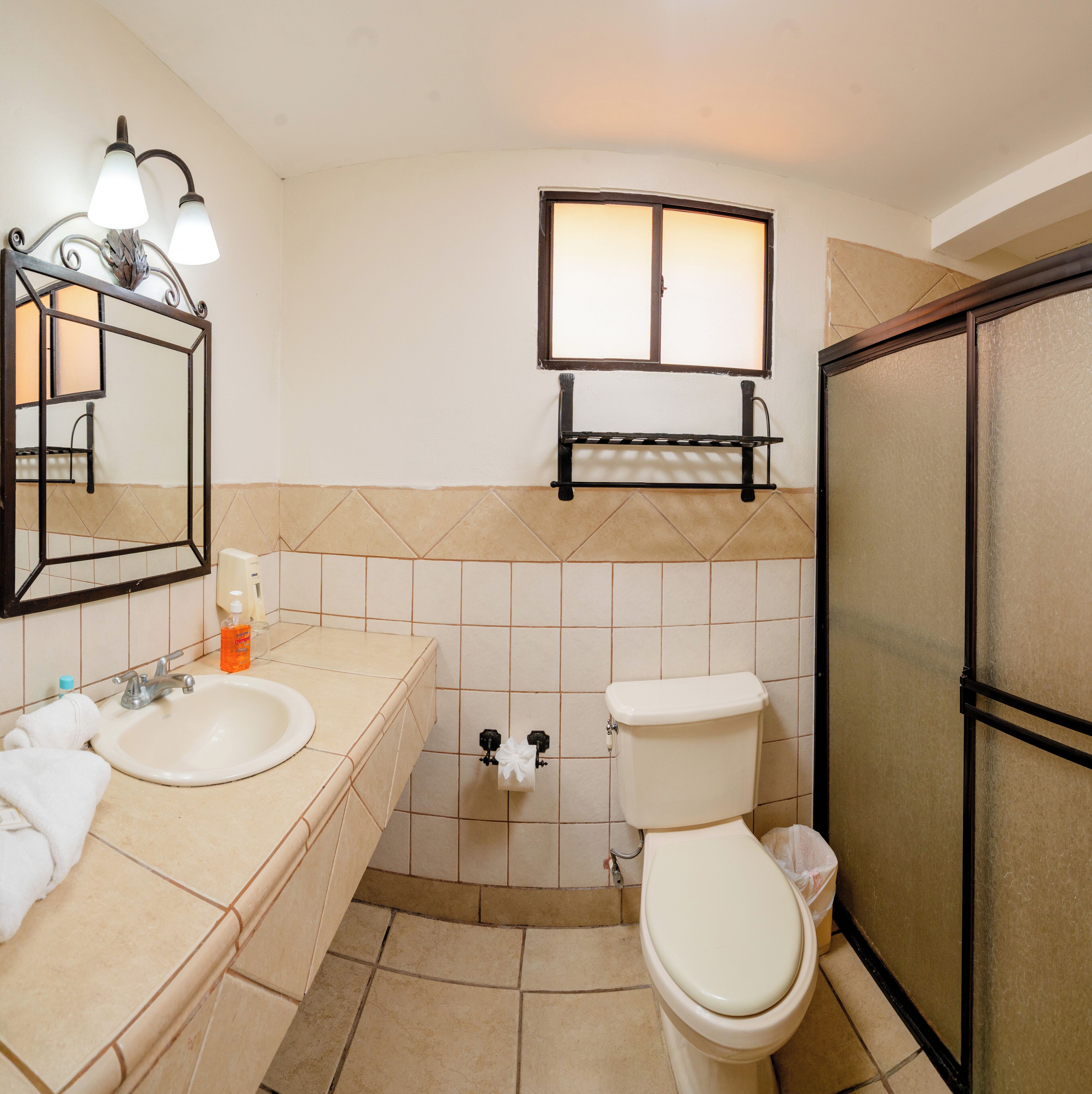 A bathroom with a sink, toilet, and shower.