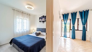 Un dormitorio con cama, mesita de noche y lámpara de pared.