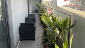 A balcony with potted plants, a seating area, and a view of the cityscape. - Experience luxury & comfort at Maison D'Ophir's 3 bedrooms, billiard and more (Dakar)