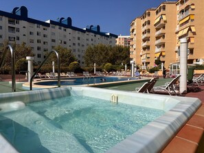 A swimming pool area with lounge chairs and a poolside deck, surrounded by multi-story buildings. - APOLO 7 - 143. Apartment very well located and very close to the beach. (Calpe / Calp)