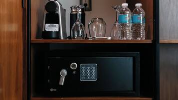 A minibar with a minibar fridge, a coffee machine, and several water bottles.