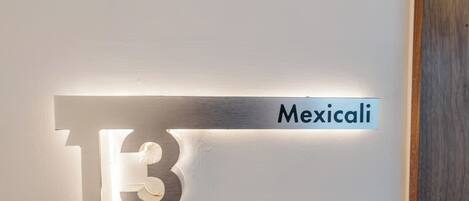 Un letrero en la pared con el número '13' y la palabra 'Mexicali'.
