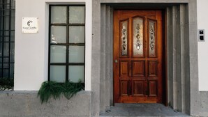 Una porta di legno con decorazioni elaborate, un cartello sopra e una finestra con vetro satinato.