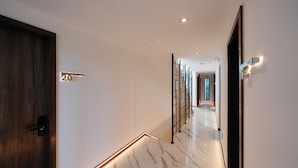 Un pasillo moderno con piso de mármol, una puerta de madera y un letrero con el número 20.