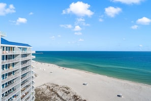 A beachfront hotel with multiple balconies, a sandy beach, and a clear blue ocean. - 2 Bedroom Lighthouse w/Bunk,  3 Pools! Direct Beachfront.  Free Daily Activities (Gulf Shores)