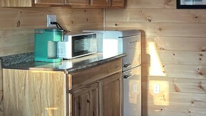 A kitchen with wooden cabinets, a microwave, and a coffee maker.