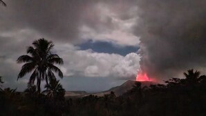 Une éruption volcanique avec de la lave visible sur fond de ciel nuageux.