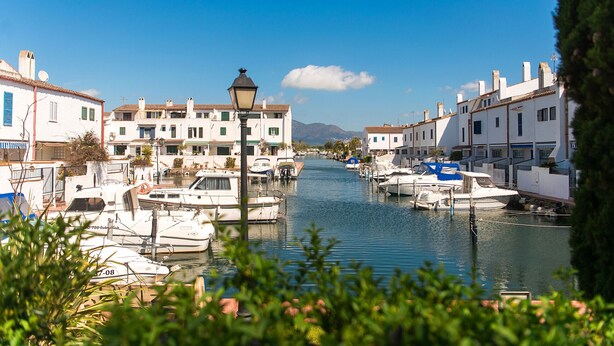 A canal lined with white buildings and boats docked along the water. - WELCS CASA ADOSADA 241 EMP con terraza al canal (Empuriabrava)