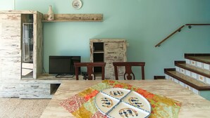 A room with a wooden table, chairs, a television, and a staircase. - WELCS CASA 242 EMP con piscina y vista al canal (Empuriabrava)