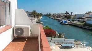 A balcony with a view of a canal, boats, and buildings. - WELCS CASA 242 EMP con piscina y vista al canal (Empuriabrava)