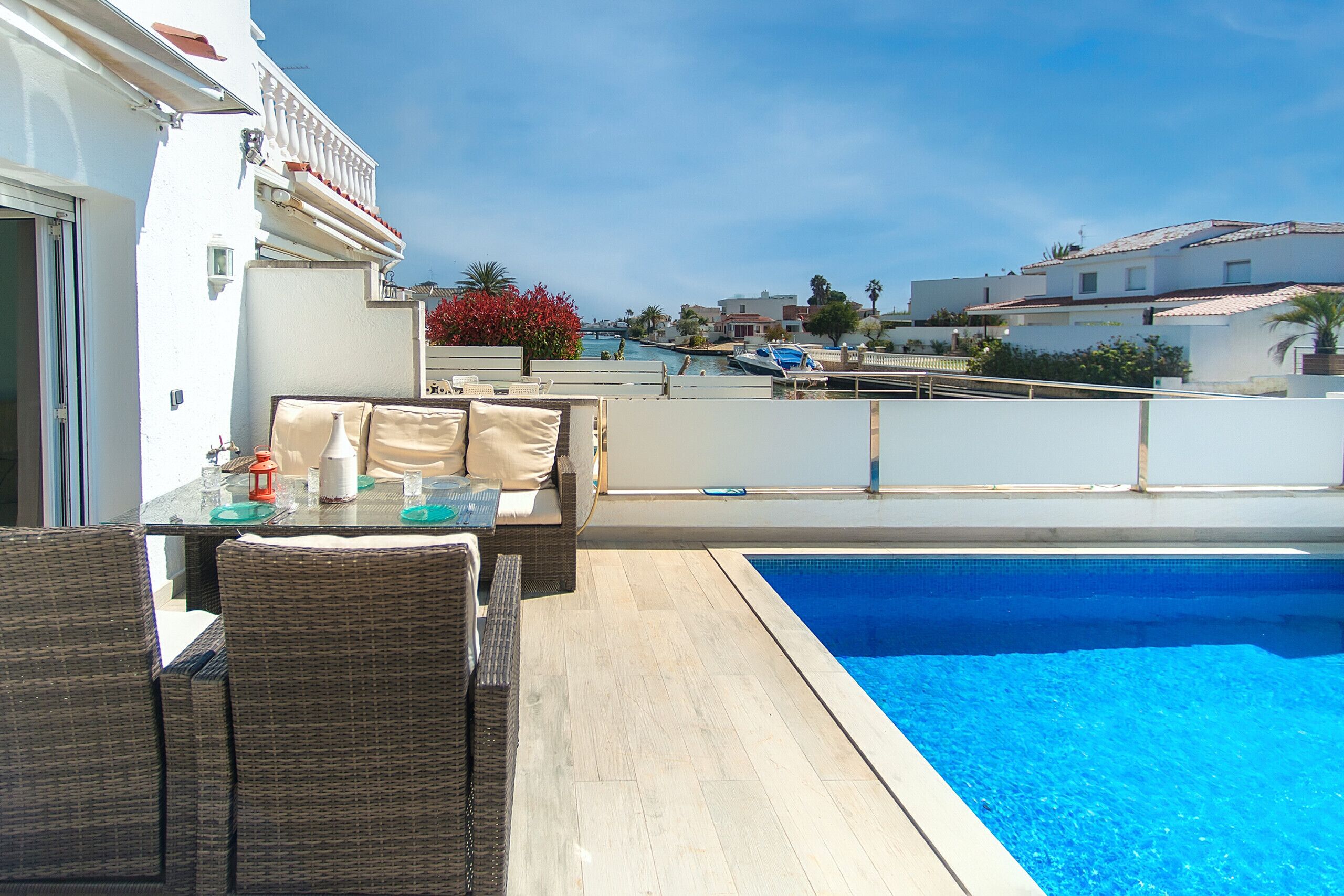 A rooftop pool area with a dining setup and a view of the surrounding neighborhood.